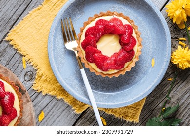 Strawberry tart, popular French pastry or Italian. Served on a plate placed on a rustic wooden table. Seasonal dessert. 