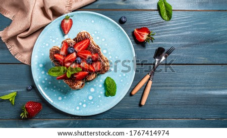 Strawberry tiramisu with mascarpone and blueberry. Traditional italian dessert tiramisu with strawberry on rustic background. Long banner format, top view.