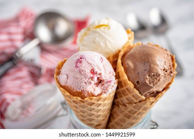 fresa, vainilla, helado de chocolate con cono de gofre sobre fondo de piedra de mármol