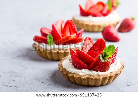 Strawberry vanilla cream cheese tarts over light gray background  