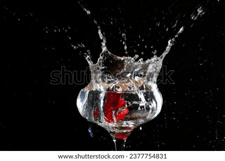 Strawberry in a wine glass with spashes and a black background