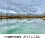 Strawtown Koteewi Park lake in Noblesville Indiana reflecting the billowy clouds on its glass like water.