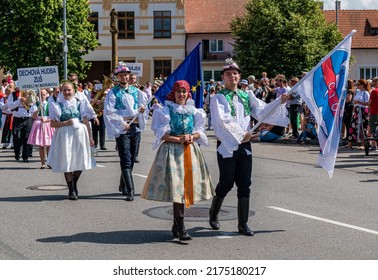 Straznice, Czech Republic - June 25, 2022 International Folklore Festival. A boy and a girl in costumes carry the CIOFF flag