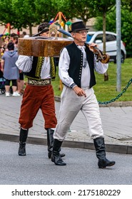 Straznice, Czech Republic - June 25, 2022 International Folklore Festival. Two men in folk costumes carry kontarabas