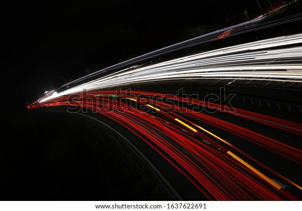 Stream of light\
trails on busy freeway at\
night