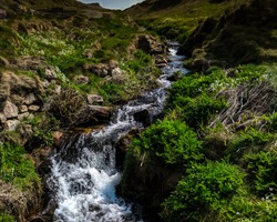 Stream Of Water Between Two Hills And Stones. Beautiful River With Fast Flowing Water. Picturesque English Landscape With Water.