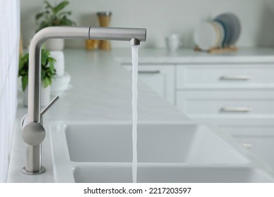 Stream of water flowing from tap in kitchen, space for text