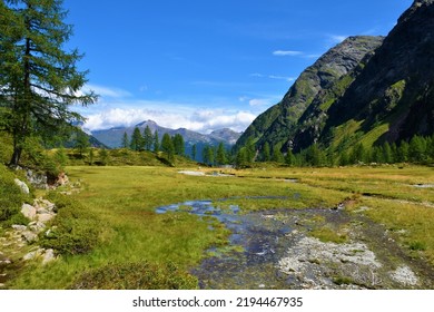 Stream Of Water Flowing Through An Alpine Meadow At Gradenmoos Basin In Gradental Valley In Schober Group Sub-range Of Hohe Tauern In Central Eastern Alps, Carinthia, Austria And Stanziwurten Mountain