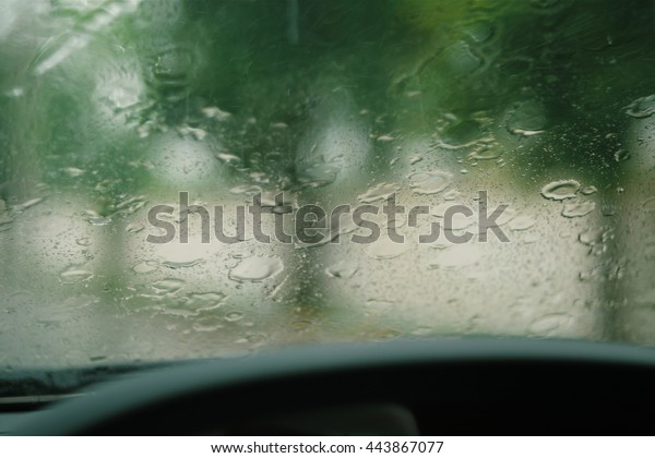 Stream of water in heavy rain. Raindrops on\
mirror car. Blur effect.