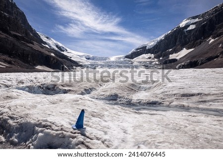A stream of water runs off the Athabasca Glacier in the summer. The icefall from the Columbia Ice Cap is in the background.