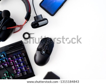 streaming games concept, top view a gaming gear, mouse, Webcams, keyboard, joystick, headset and mouse pad on white table background.