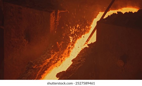 Streams and channels of molten metal. Stock footage. Worker crushes place for molten metal to flow with metal shelf. Solidified metals in path of molten alloy - Powered by Shutterstock