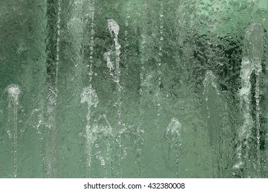 Streams / Jets Of Water On Glass Wall. Closeup Fragment Of Modern Fountain. 