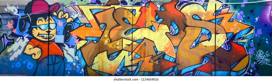 Street art. Abstract background image of a full completed graffiti painting in beige and orange tones with cartoon character
