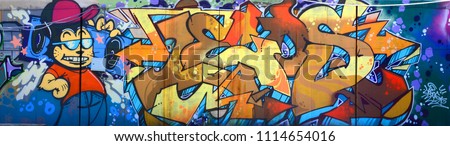 Street art. Abstract background image of a full completed graffiti painting in beige and orange tones with cartoon character