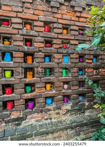 Street art, colorful cups in brick wall.