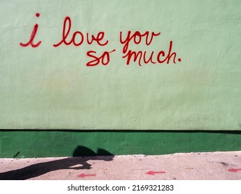 Street art mural in red cursive writing on green background with a dark green line at the bottom "I love you so much" taken in Austin Texas - Shutterstock ID 2169321283