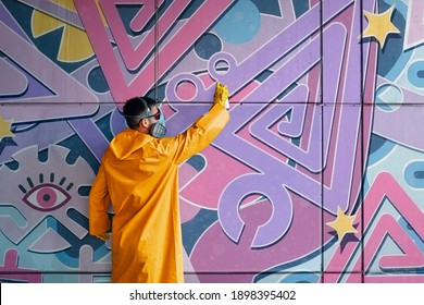 Street artist painting colorful graffiti on wall. Modern urban art concept - Shutterstock ID 1898395402