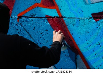 Street Artist Paints Colorful Graffiti On A Common Wall - Modern Art Concept, Hand With A Sprayer Spray Paint On The Wall