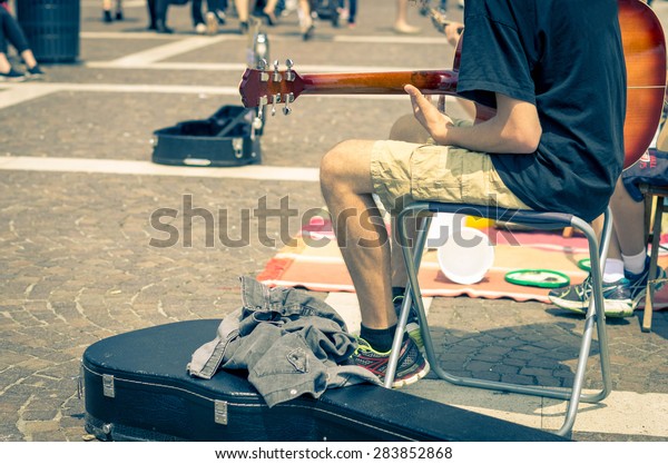 Street artist plays guitar - art, lifestyle and\
music concept