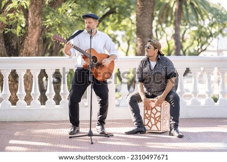 Street band performing at the street. Musicians palying guitar and flamenco box