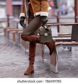 Street, bright style. A young girl in leather pants, a warm red jacket. High boots. Details. Sguare image photo