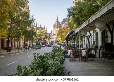 Street of Budapest with a pavement cafe and a view at the Hungarian Parliament Building on a bright autumn day