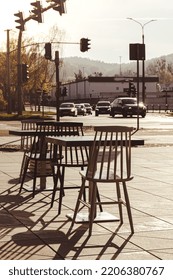 Street Cafe Chairs And Tables In Sun Rays. No People. Empty Outdoor Table In Street Cafe. Traffic