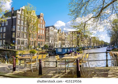 Street cafe on the canal in Amsterdam at sunny spring day. The Netherlands