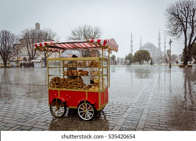 Street cart vending selling simits with Sultan Ahmed Mosque in background, Istanbul