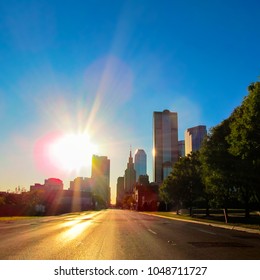 Street Cityscape At Sunset In Downtown Of Dallas, Texas, USA.
City Skyline With Modern Buildings And Skyscrapers In City Center District Against A Bright Sun. View From Empty Road.