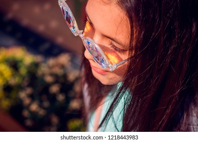 street close-up photo with a young beautiful girl model with dark long hair in glasses kaleidoscopes - Powered by Shutterstock