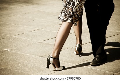 Street dancers performing tango dance. Aged warm tone.