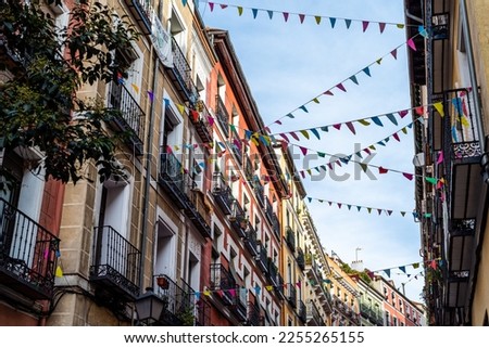 Street decorated with pennants hanging from the facades in the traditional neighborhood of Embajadores in Madrid