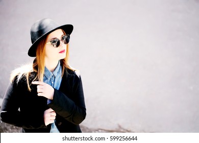 Street fashion concept - closeup portrait of a pretty girl. Wearing hat, sunglasses, red lips. Fall fashion. Toned style instagram filters