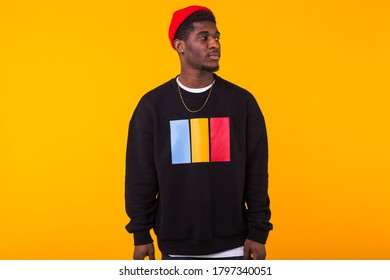 Street Fashion Concept - Studio Shot Of Young Handsome African Man Wearing Sweatshirt Against Yellow Background.