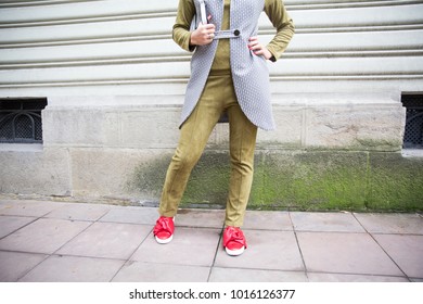 Street fashion look, stylish spring outfit. Woman in velvet olive costume on the street. Girl in green costume and red leather shoes posing in the city - Powered by Shutterstock