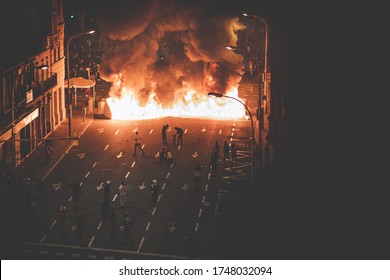 Street in flames with protestants - Shutterstock ID 1748032094