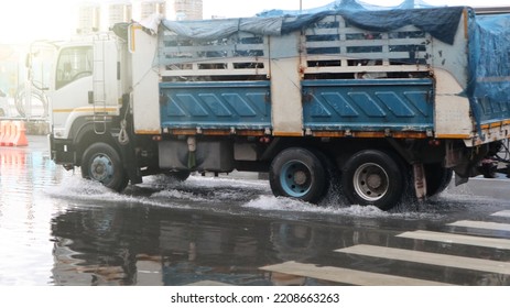 Street Flooding And Storm Surge In Street Of Neighborhood With A Truck Driving Through Shallow Splashing Water In The Flooded Street 