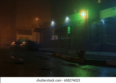 Street with fog and green cross pharmacy