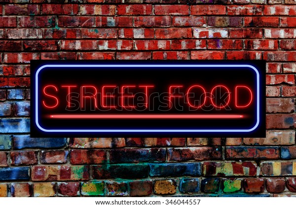 Street Food\
Neon sign on a Graffiti. Bricks\
wall