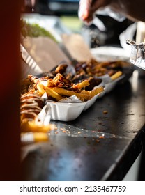 Street Food Sriracha Chicken Wings And Fries With Chilli Flakes Being Sprinkled