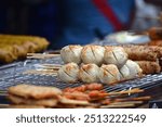 street food of Thailand.Grilled meatballs skewer bamboo on white plate with spicy sauce on wood table, Beef balls tendon grilled street food of Thailand.