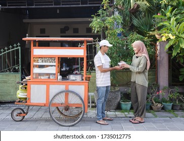 street food vendor handing a bowl of bakso or meatball to customer - Powered by Shutterstock