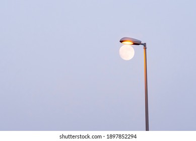 Street Lamp And Full Mon In Blue Sky