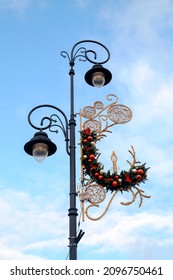 Street Lamp Lantern Decorated With Christmas Holiday Decorations  And Christmas Balls And Lights. Daytime On Blue Sky Background. Warsaw Poland Old Town Decoration.