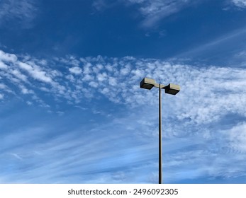 A street lamp in Phoenix, Arizona, USA isolated against deep blue desert sky with beautiful scattered cloud formation. Copy space. - Powered by Shutterstock