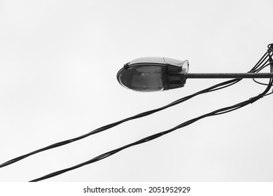Street lamp and two parallel electrical wires. Black and white photography. Vintage