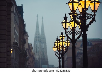 Street lamps and Votive Church during chilly autumn evening in Vienna - selective focus on the lantern