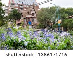 Street landscape or cityscape  in spring surrounded by blooming flowers. House  resembling an old castle called Villa Normandy, town Mar del Plata